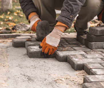 Laying paving slabs close-up. Road surface, construction. Sidewalk repair. Worker laying stone paving slab. Laying tiles in the city park garden .