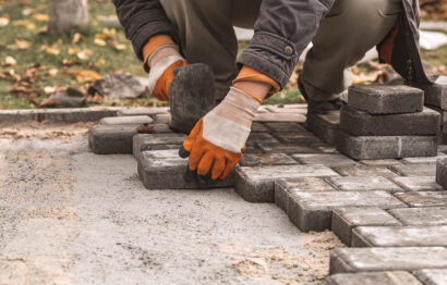 Laying paving slabs close-up. Road surface, construction. Sidewalk repair. Worker laying stone paving slab. Laying tiles in the city park garden .